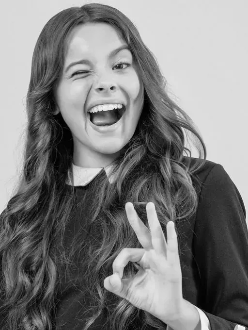Una fotografía en blanco y negro de una niña haciendo el signo de ok.