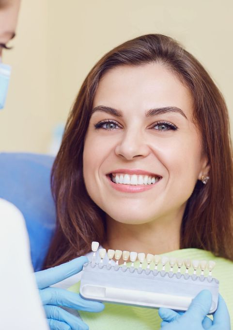 Una mujer mira sus dientes a través de una lupa.