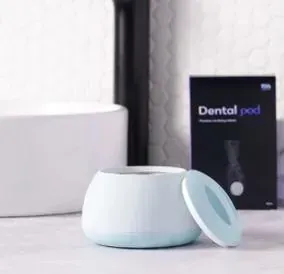 Cápsula dental de color blanco y azul con tapa abierta, al lado de un recuadro negro que dice 