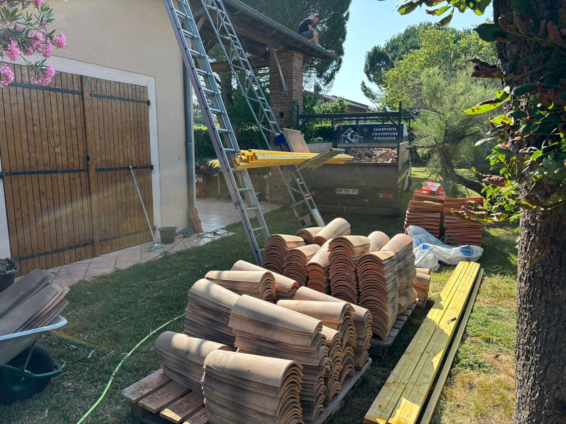 Une pile de tuiles devant une maison