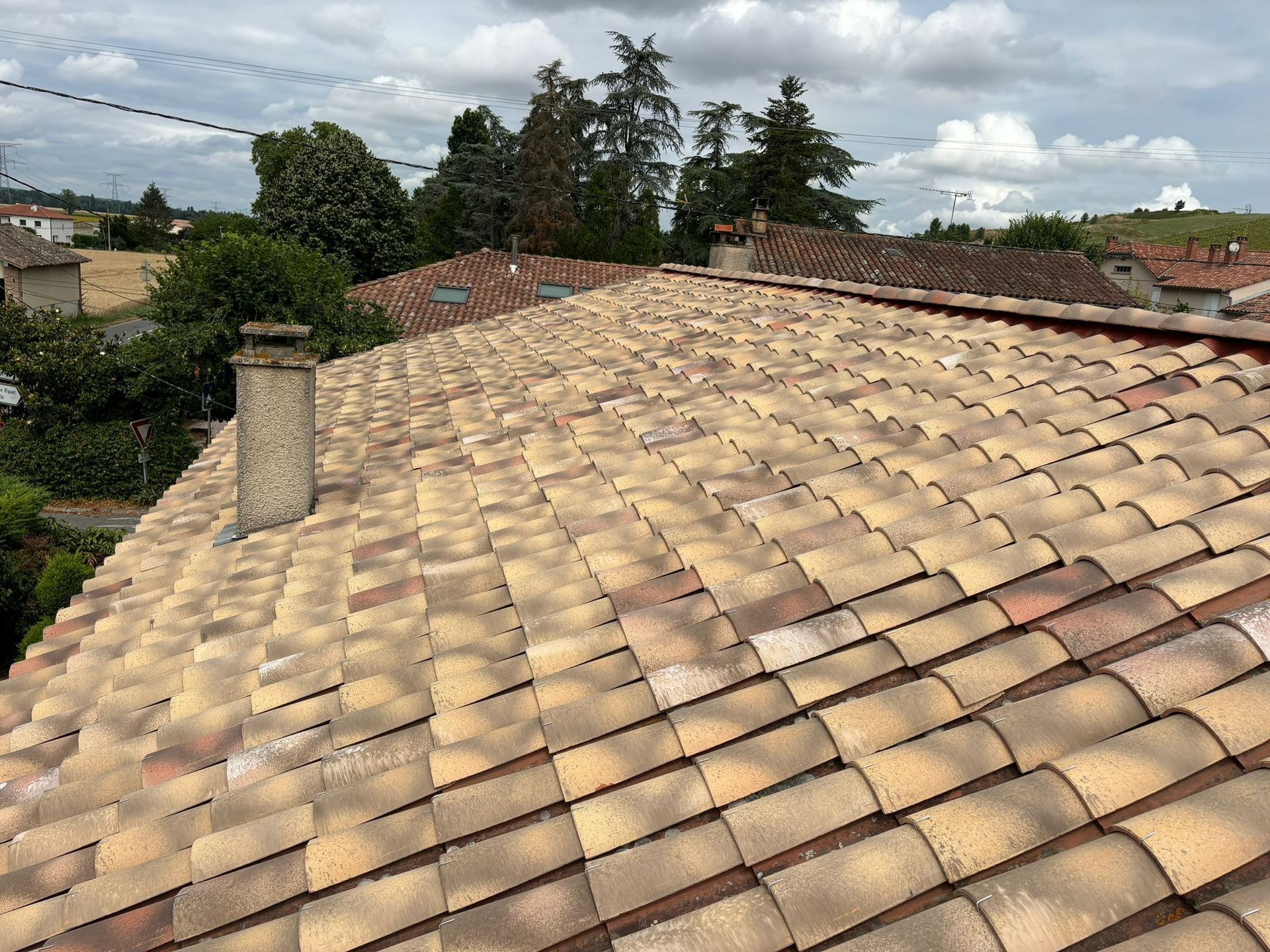 Un toit en tuiles et sa cheminée