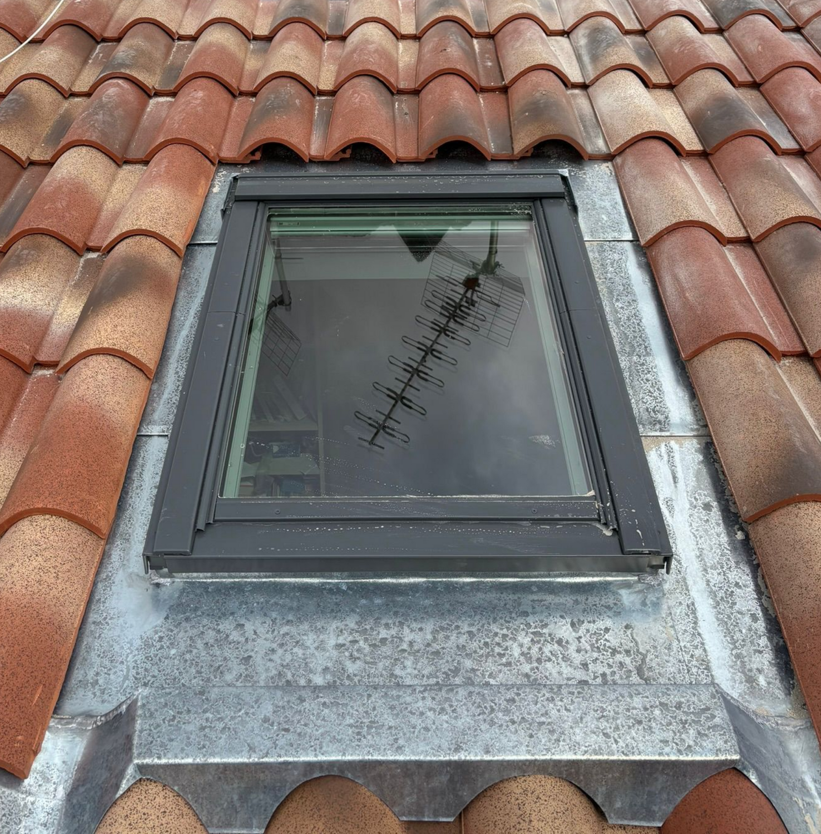 Une fenêtre de toit sur un toit en tuile