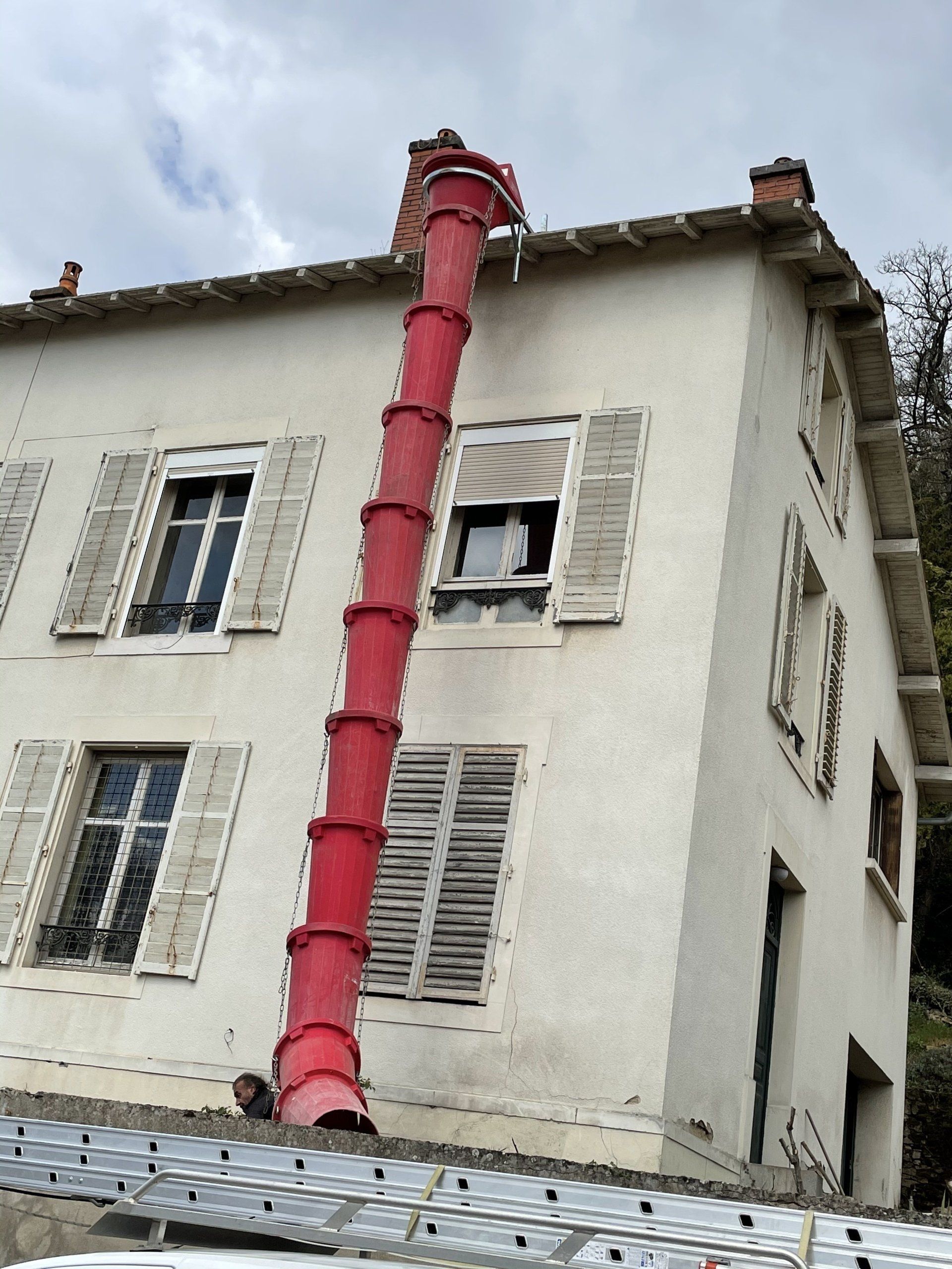 Tuyau de déblai rouge fixé à une maison à deux étages