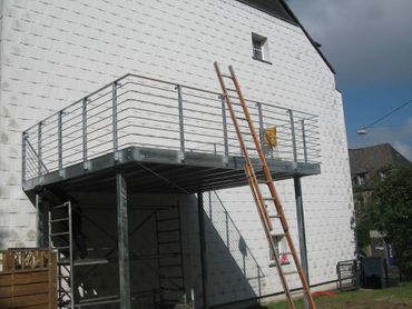 Metallgeländer an einem Balkon an einem weißen Haus