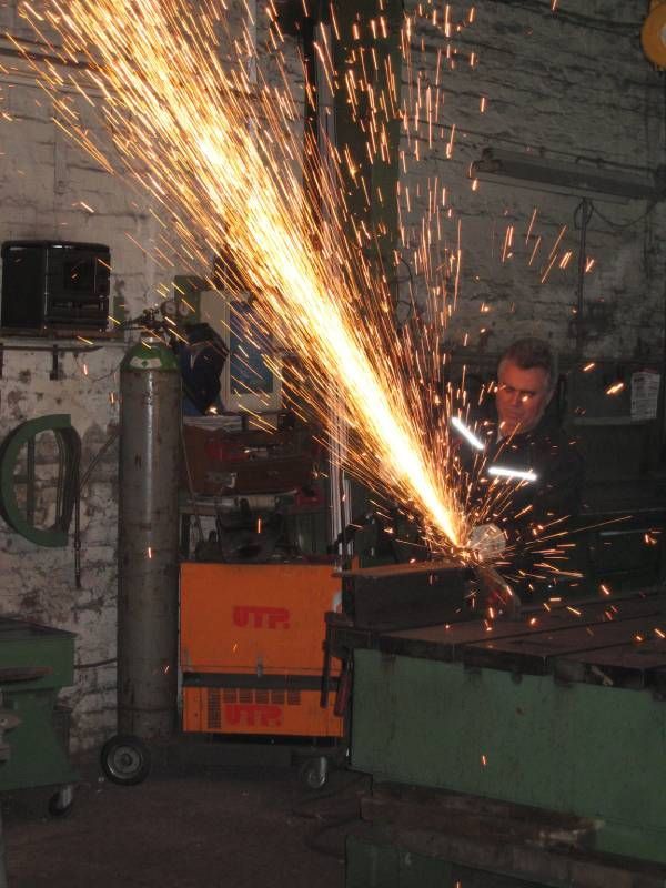 Person arbeitet mit einem Schweißgerät in einer Werkstatt
