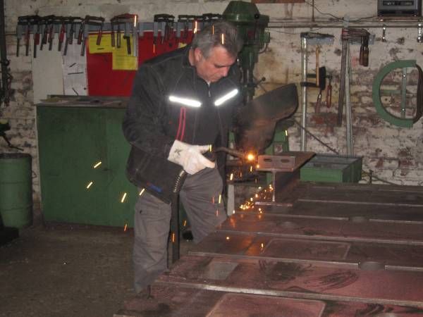 Person arbeitet mit einem Schweißgerät in einer Werkstatt