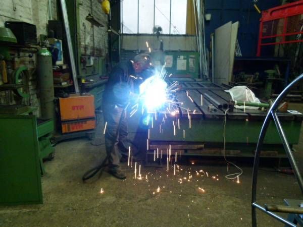 Person arbeitet mit einem Schweißgerät in einer Werkstatt