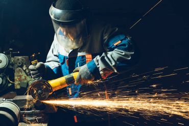 Person mit Gesichtsschutz arbeitet mit einem Schweißgerät