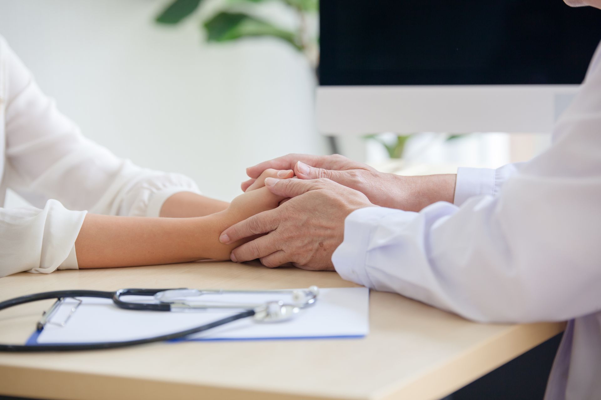 Doktor hält die Hände eines Patienten