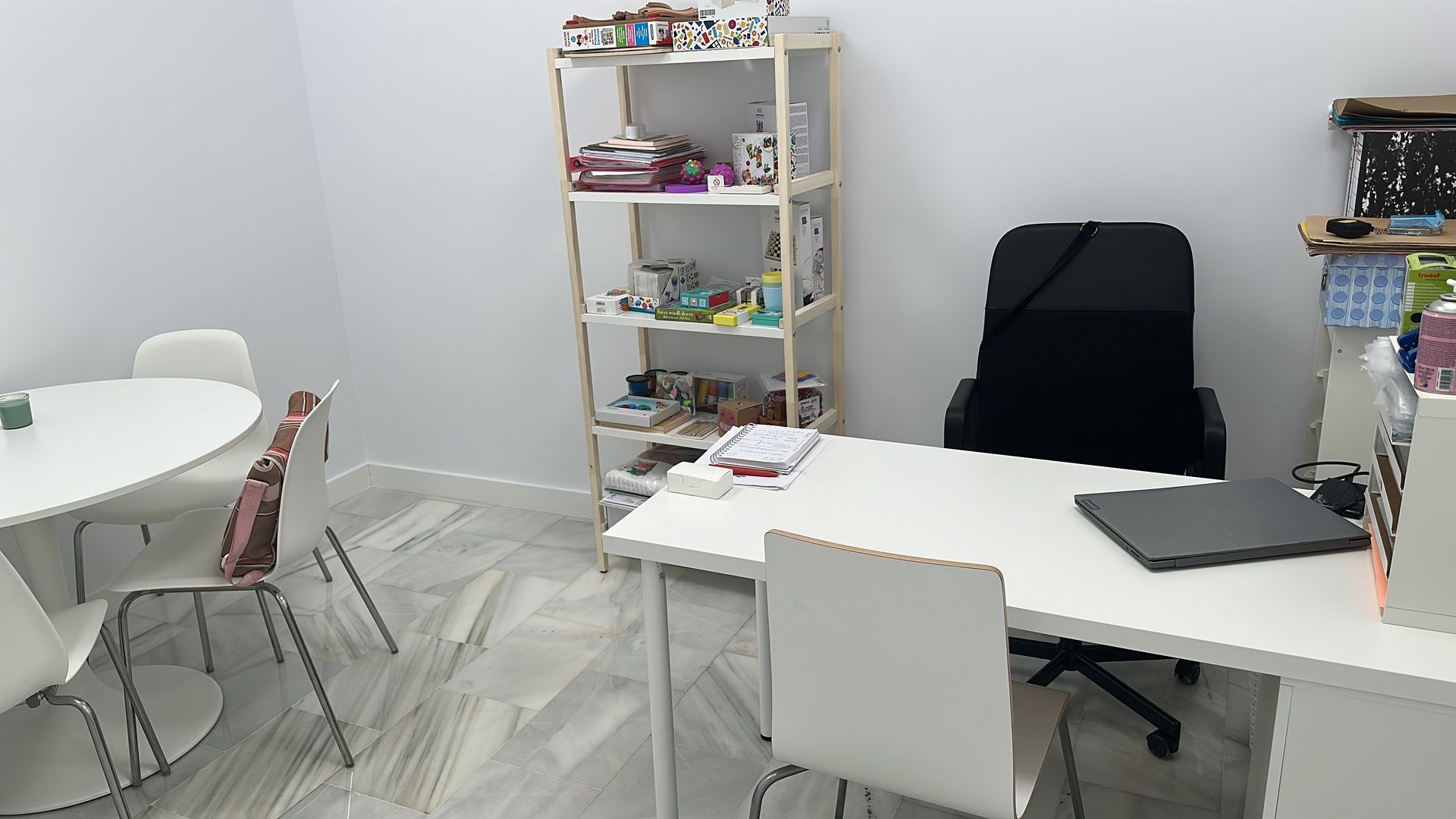 Hombre hablando con terapeuta; ambos sentados. Caja de pañuelos, vaso de agua y medicamentos sobre la mesa.