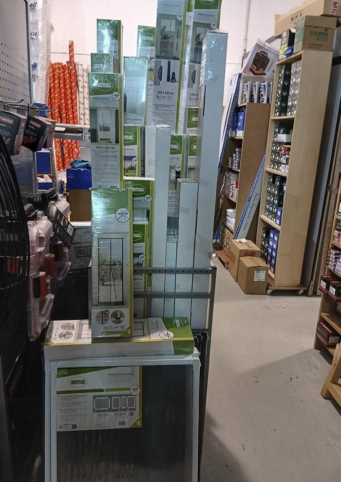 Pasillo de la tienda con cajas apiladas de electrodomésticos y estanterías de exhibición.