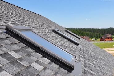 Detailaufnahme Schrägdach mit grauen Schindeln und Dachfenstern