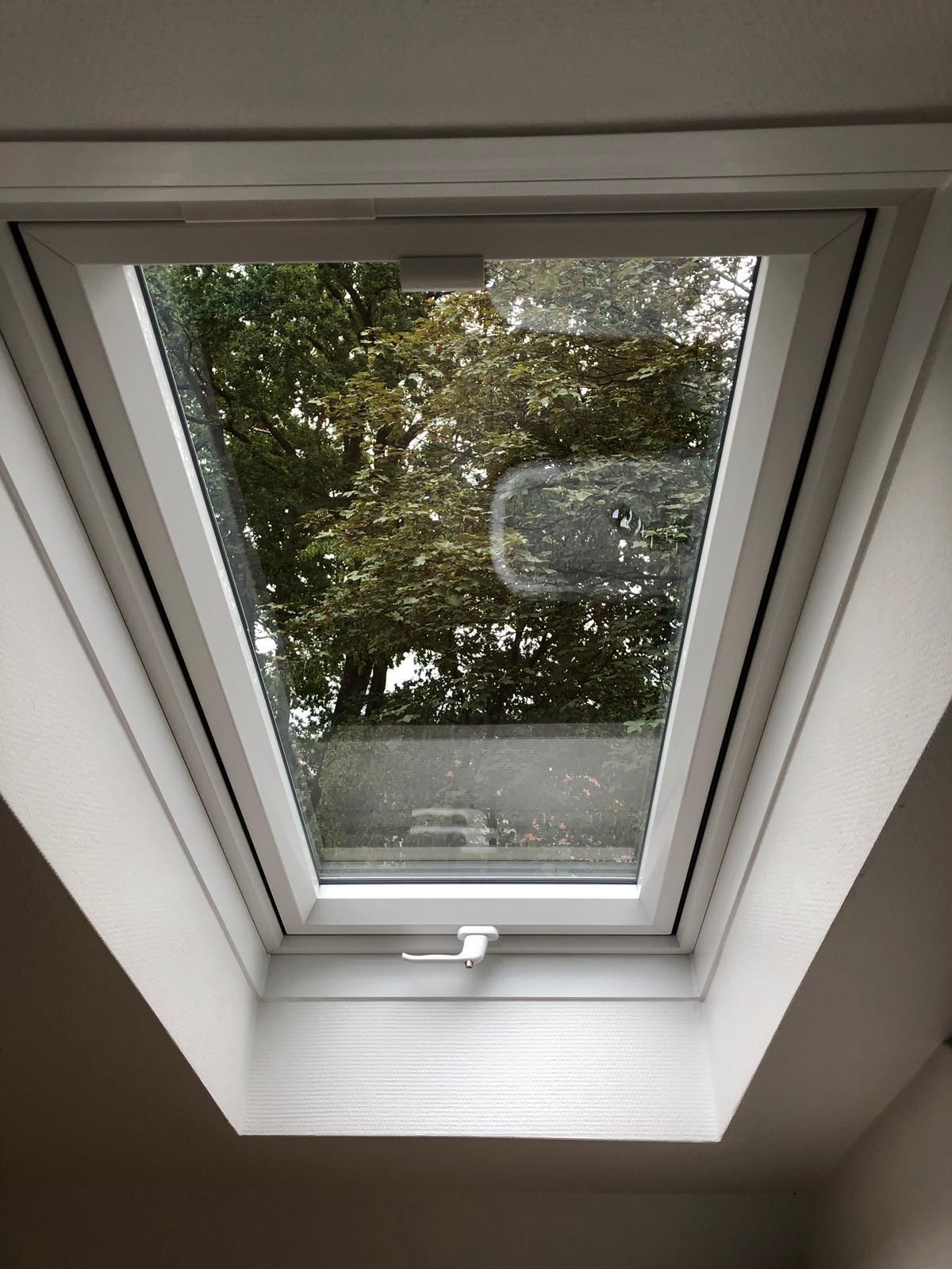 Ein Oberlicht in einem weißen Rahmen ist schräg in die Decke eingelassen.