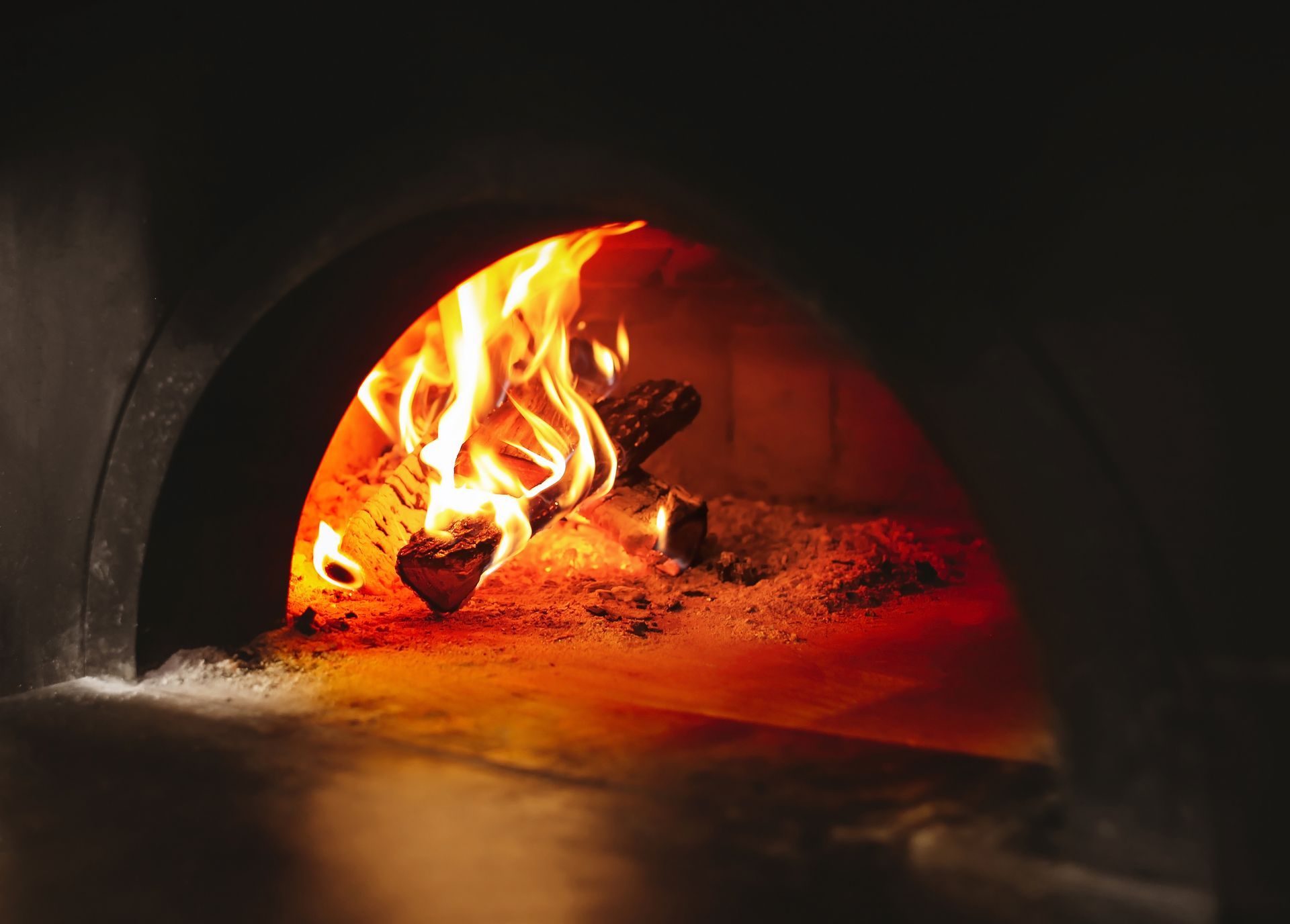 Bois de chauffage en train de brûler dans un four traditionnel dans la cuisine d'un restaurant