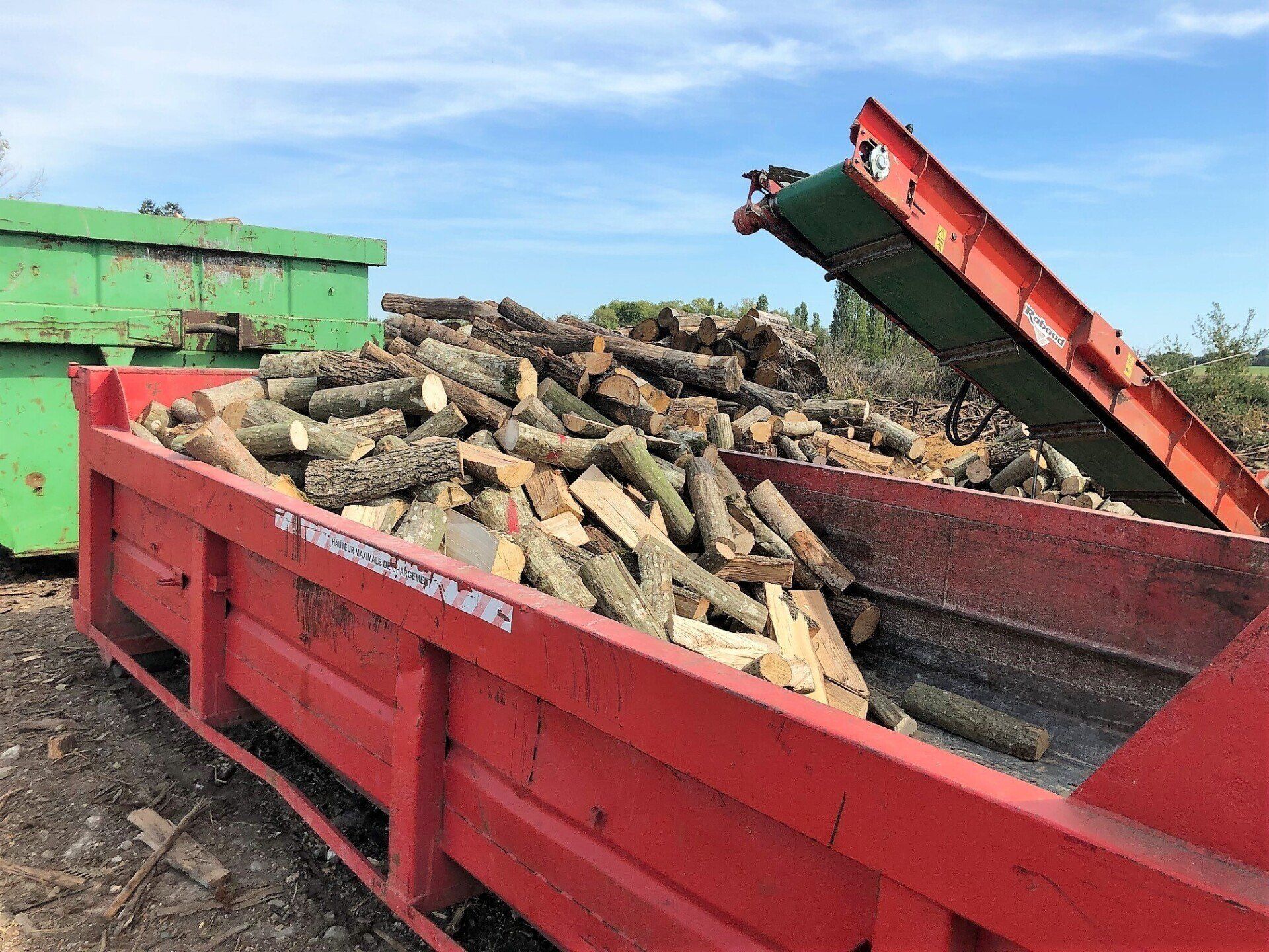 Des morceaux de bois dans une benne rouge.