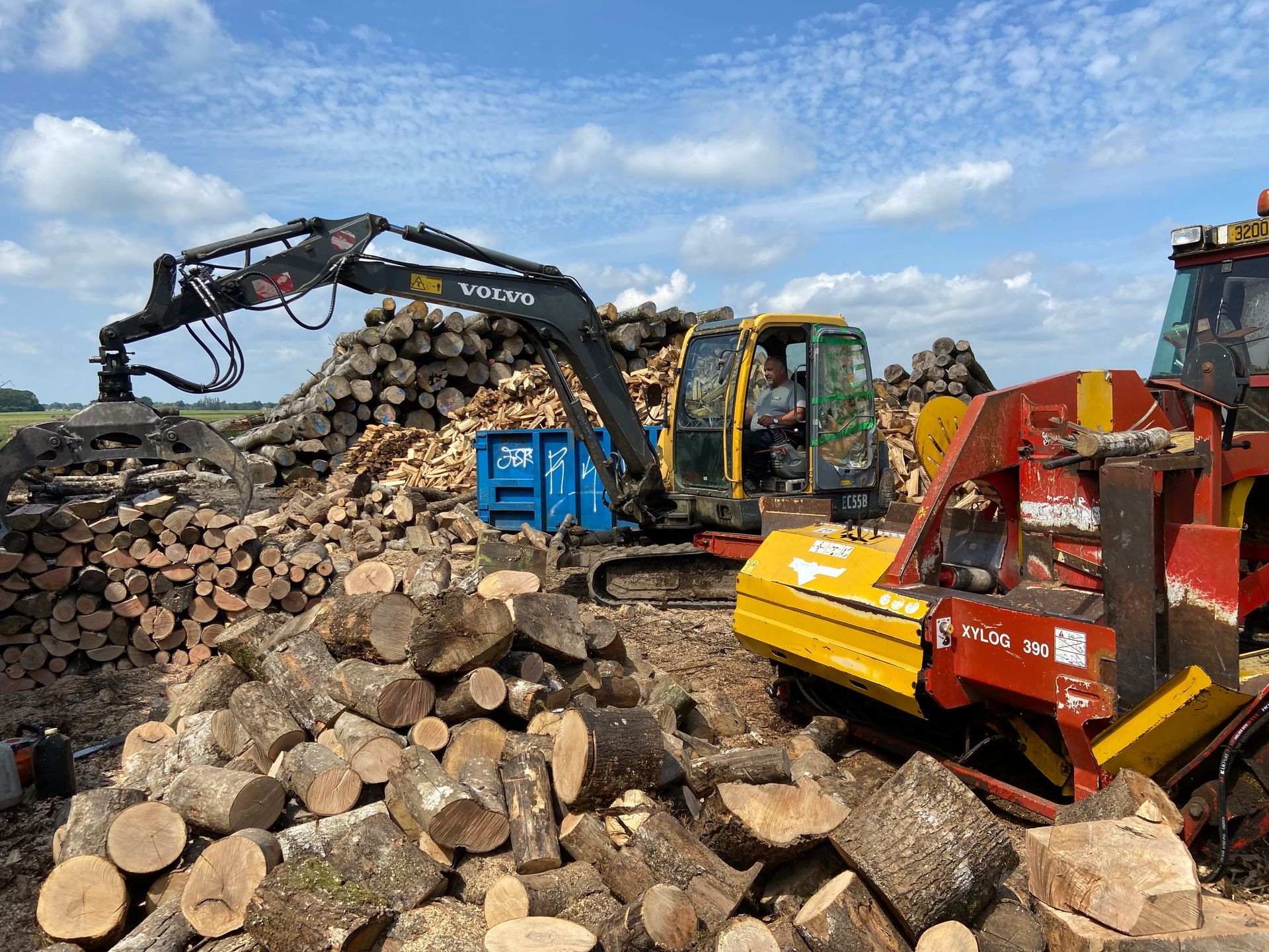 Un employé récupère du bois à l'aide d'un engin 