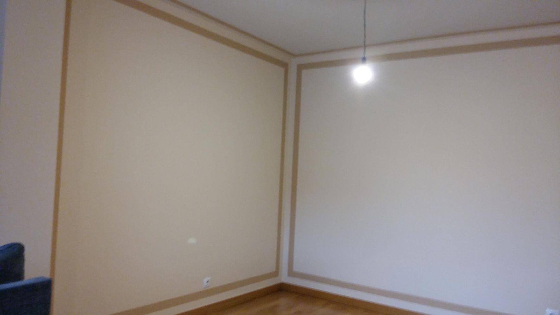 Una habitación vacía con una luz colgando del techo.