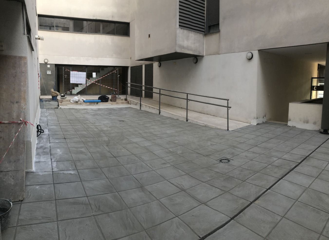 Un patio vacío con una rampa que conduce a un edificio.