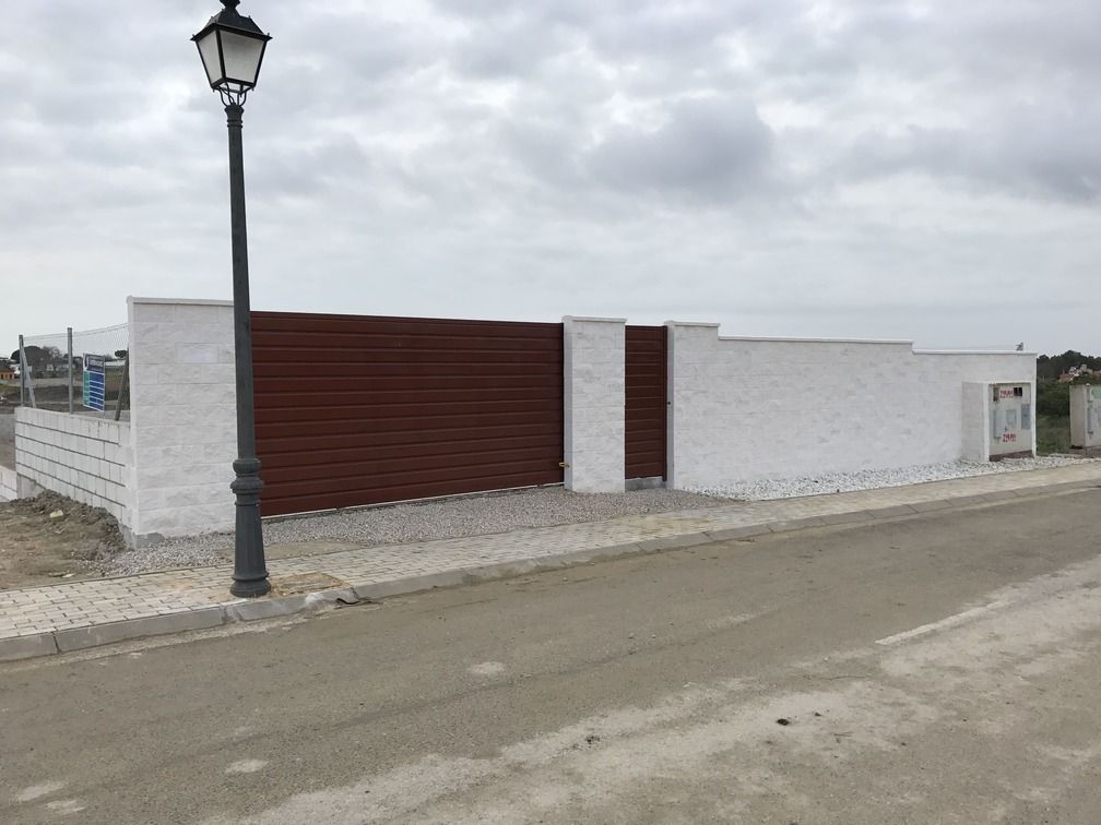 Hay una farola delante de un edificio blanco.