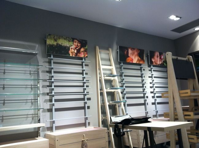 Una habitación con muchos estantes y cuadros en la pared.