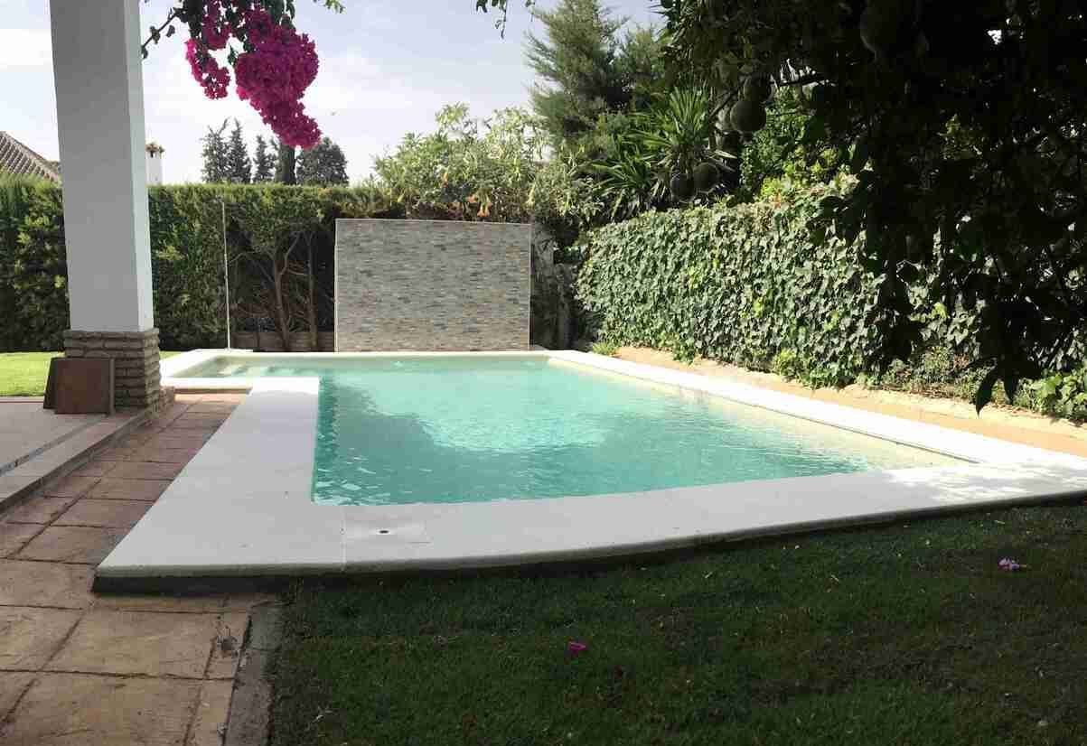 Una gran piscina en el patio trasero de una casa
