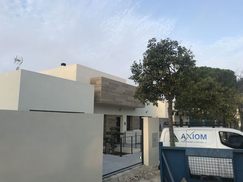 Una camioneta blanca con la palabra axioma está estacionada frente a una casa.