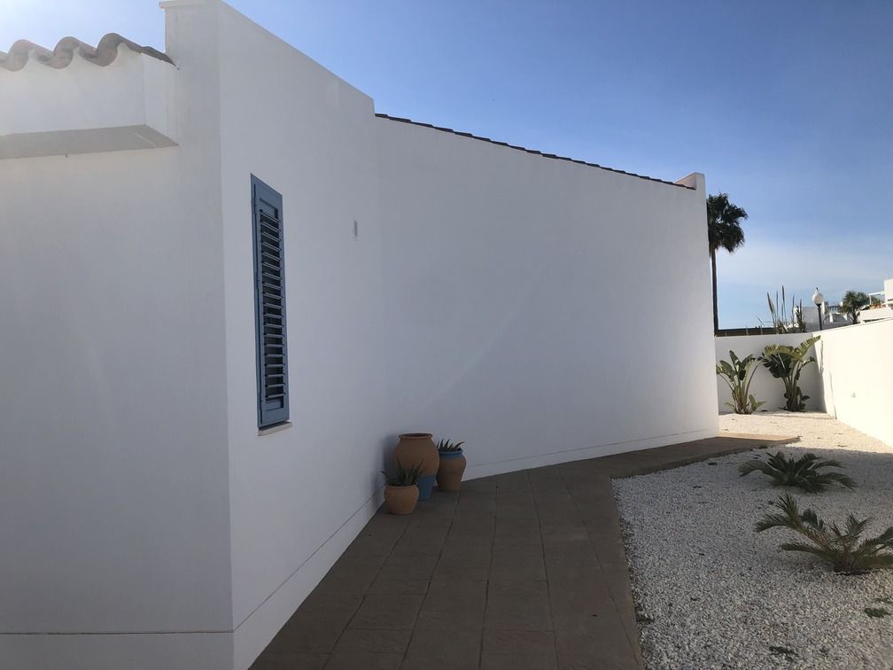 Un edificio blanco con un cielo azul al fondo.