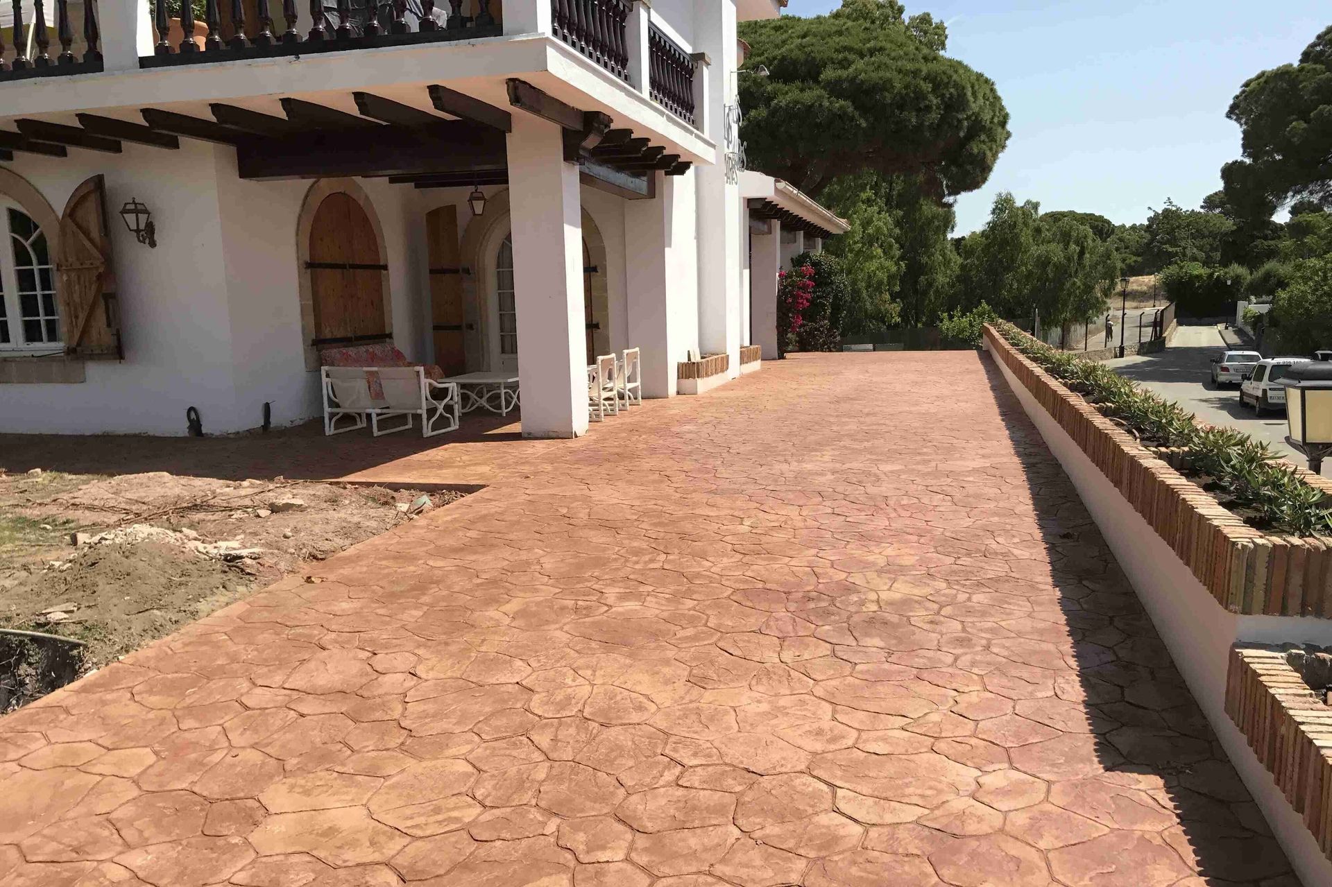 Una gran casa blanca con una entrada de ladrillos al frente.