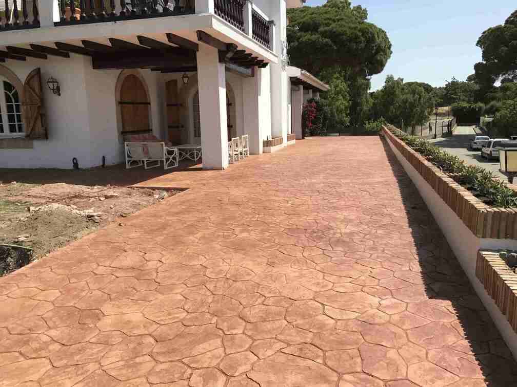 Una gran casa blanca con una entrada de hormigón delante de ella.