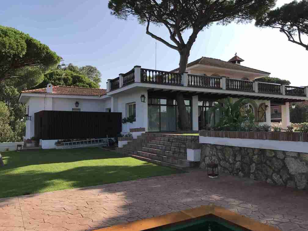 Una gran casa blanca con una piscina delante de ella.