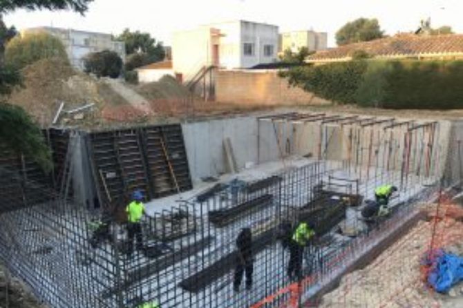 Un grupo de trabajadores de la construcción está trabajando en un muro de hormigón.
