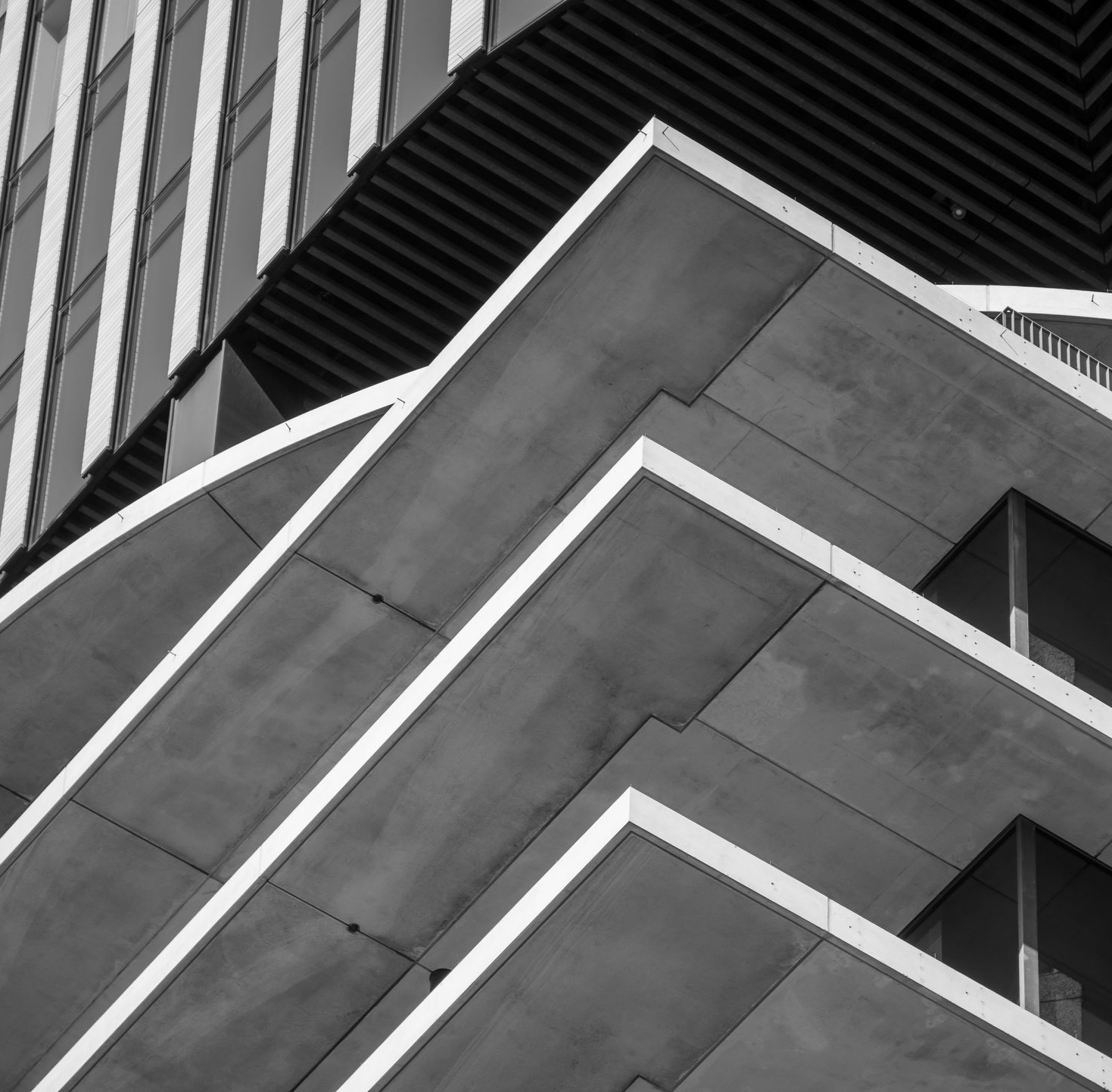 Extérieur d'un bâtiment moderne avec balcons angulaires en béton.