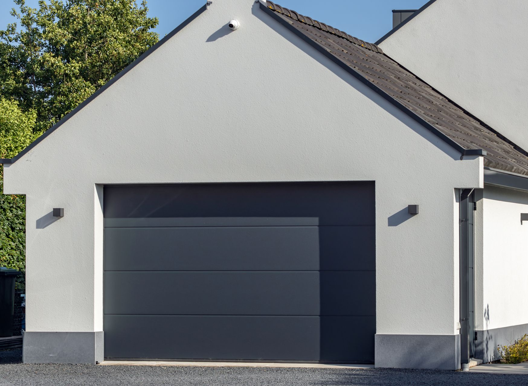 Maison moderne avec porte de garage et boiseries.