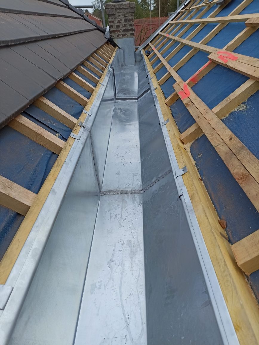 Noue de toit avec solin métallique, liteaux en bois et sous-couche des deux côtés