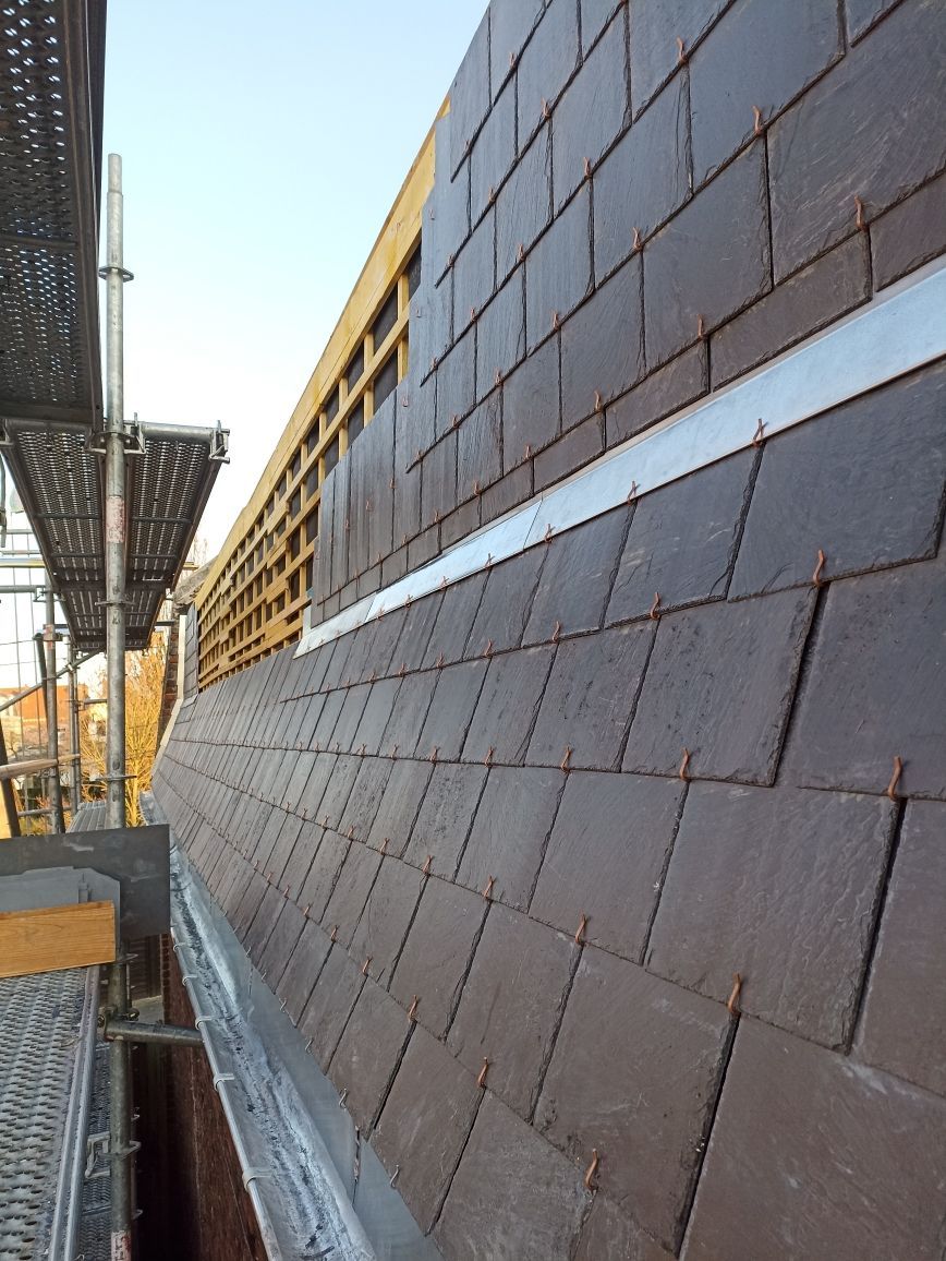 Mur de briques en construction à côté d'échafaudages et d'une façade de bâtiment