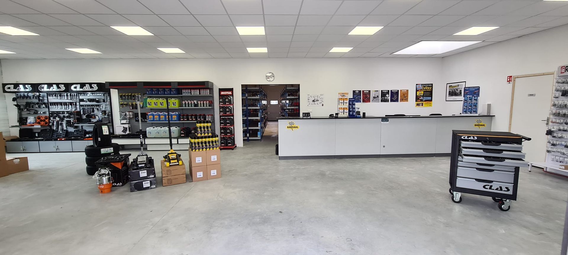 L'intérieur d'un magasin de pièces détachées automobiles avec un comptoir et des étagères.