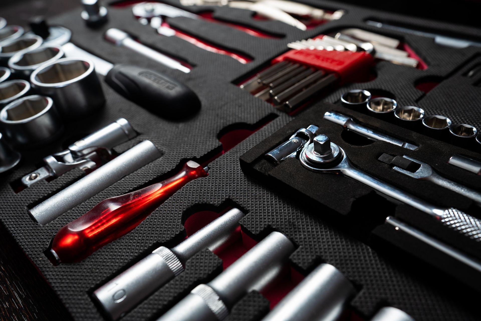 Un ensemble d'outils et de douilles métalliques variés, soigneusement rangés dans une mallette.