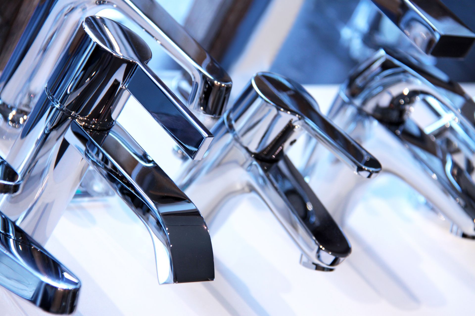 Modernes Badezimmer mit schwarz gefliesten Wänden, weisser Badewanne, Toilette, Waschbecken und Handtuchheizkörper in Fensternähe