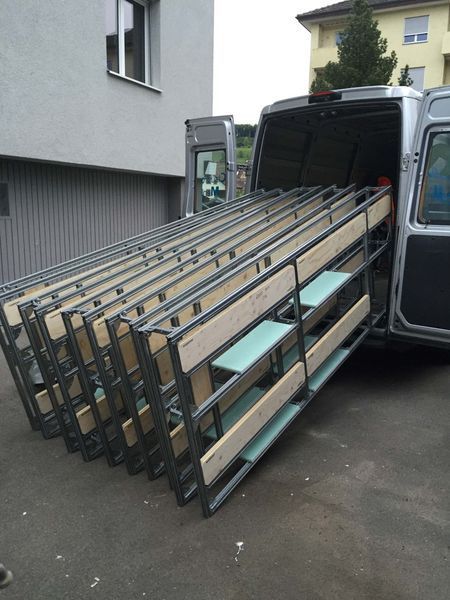 Zusammengefaltete Metallgestelle stapelten sich im Laderaum eines Lieferwagens in einer Wohnstrasse.