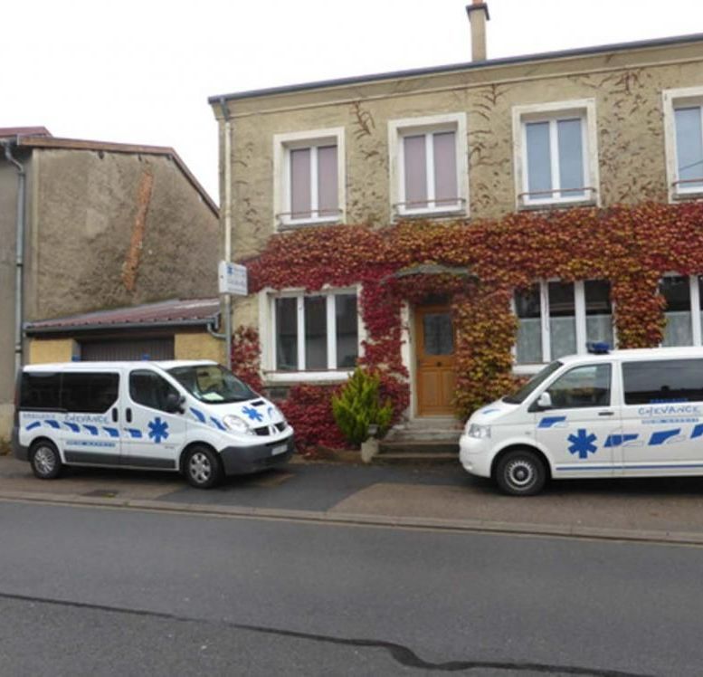 Deux VSL garés devant une maison