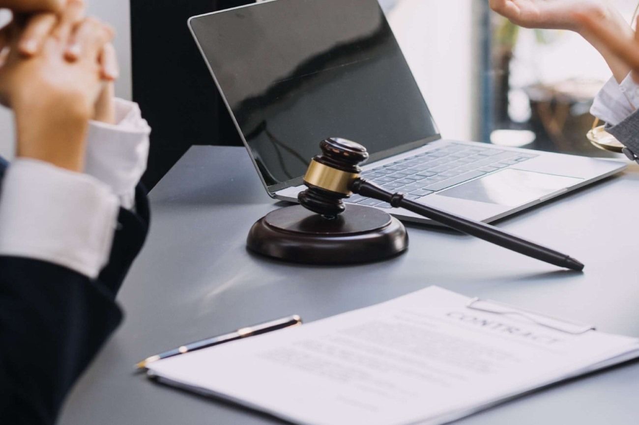 El mazo de un juez está sobre un escritorio al lado de una computadora portátil.