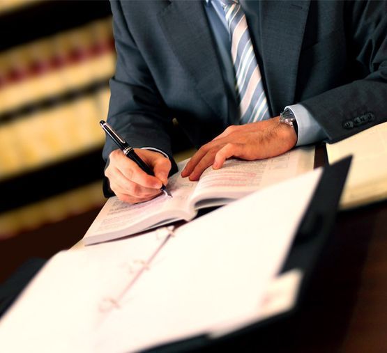Un hombre con traje y corbata está escribiendo en un cuaderno.