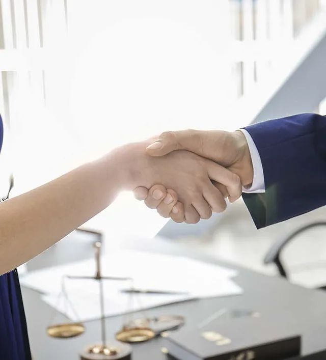 Un hombre y una mujer se dan la mano delante de una báscula.