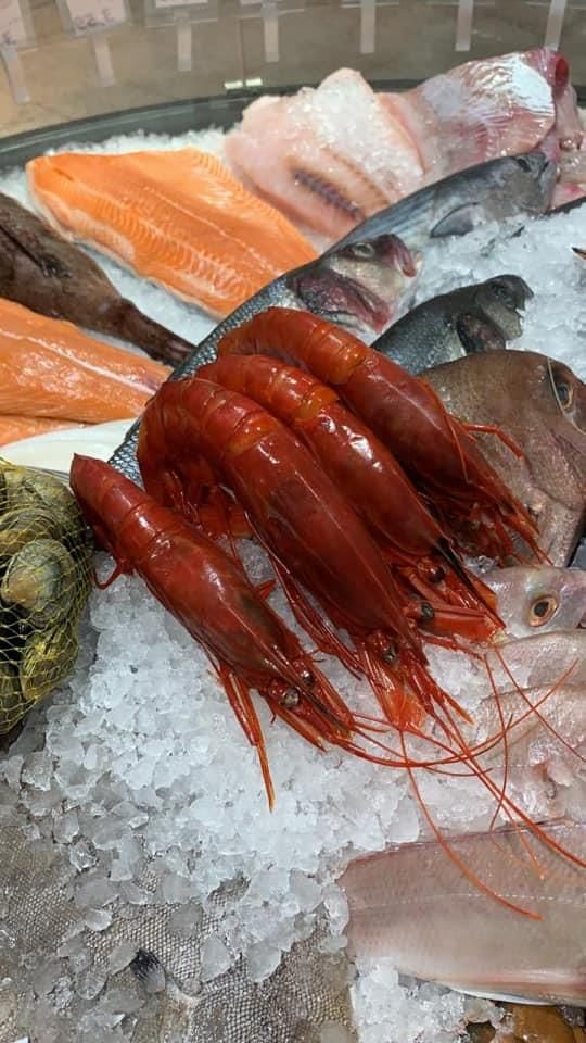 Ein Haufen Garnelen liegt auf einem Eishaufen.