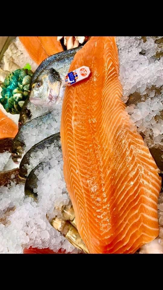 Ein Stück Lachs liegt auf einem Eishaufen.