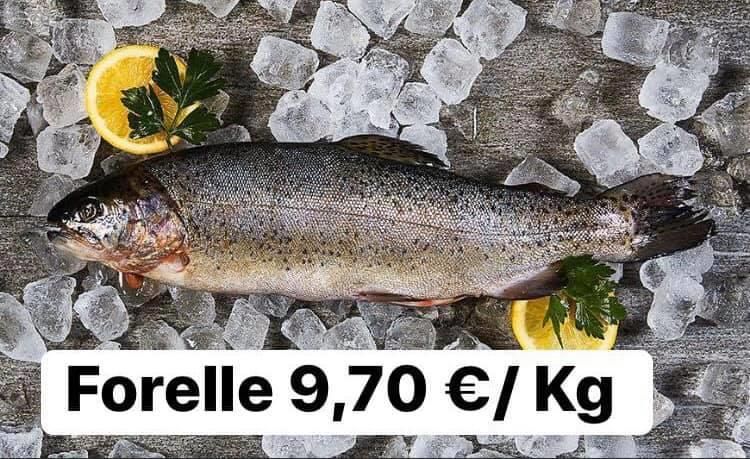 Ein Fisch liegt auf Eis und ist mit einer Zitronenscheibe bedeckt.