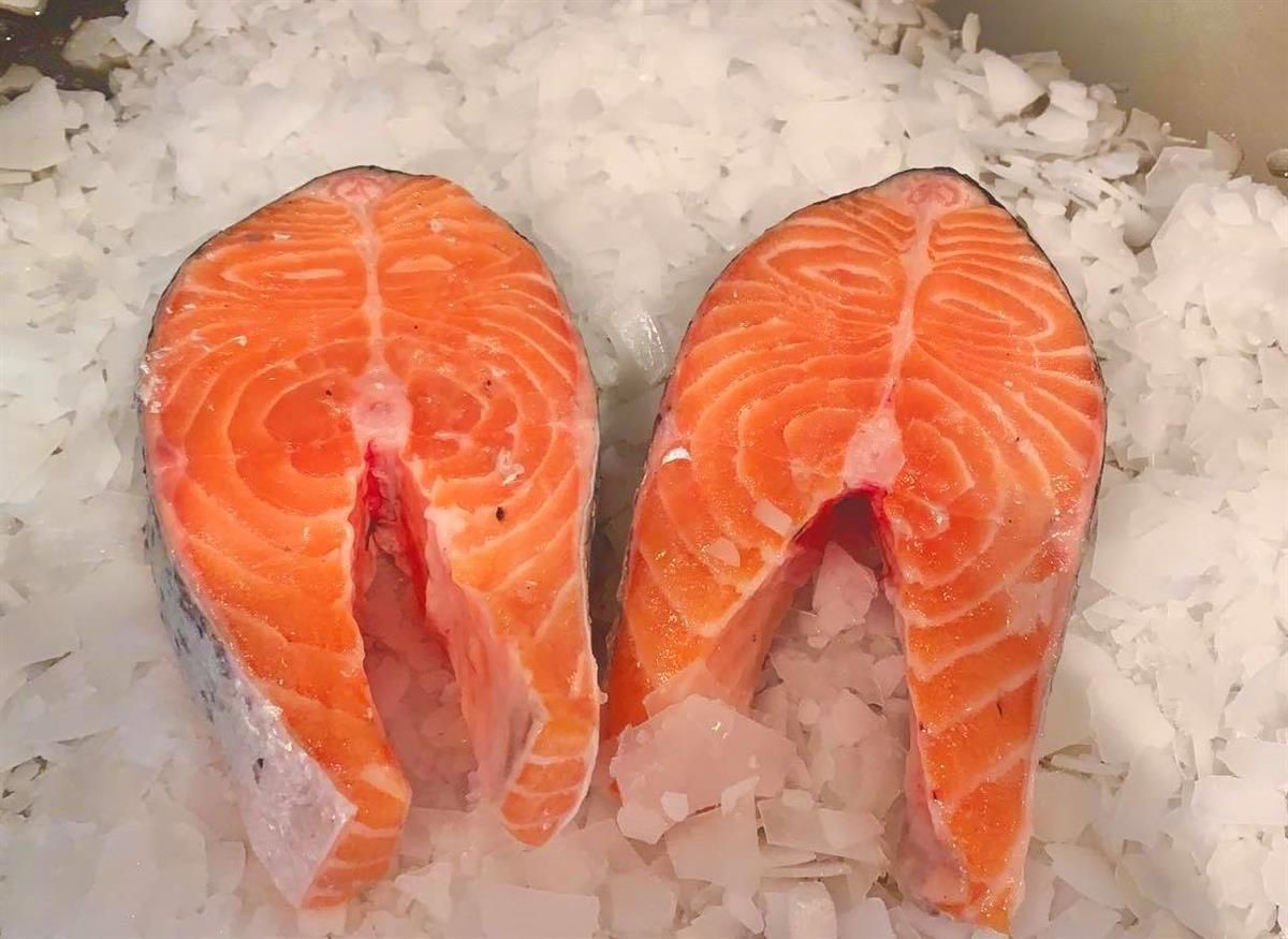Zwei Lachsstücke liegen auf Eis.