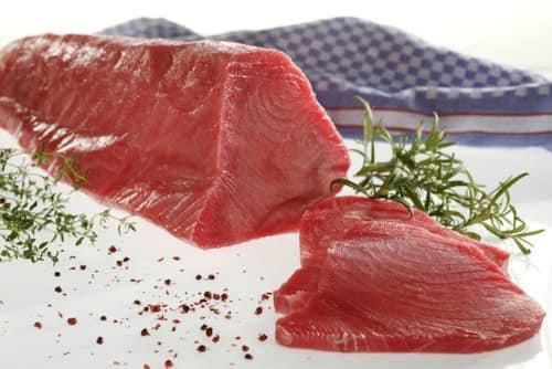 Ein Stück rohes Fleisch liegt auf einem weißen Teller.