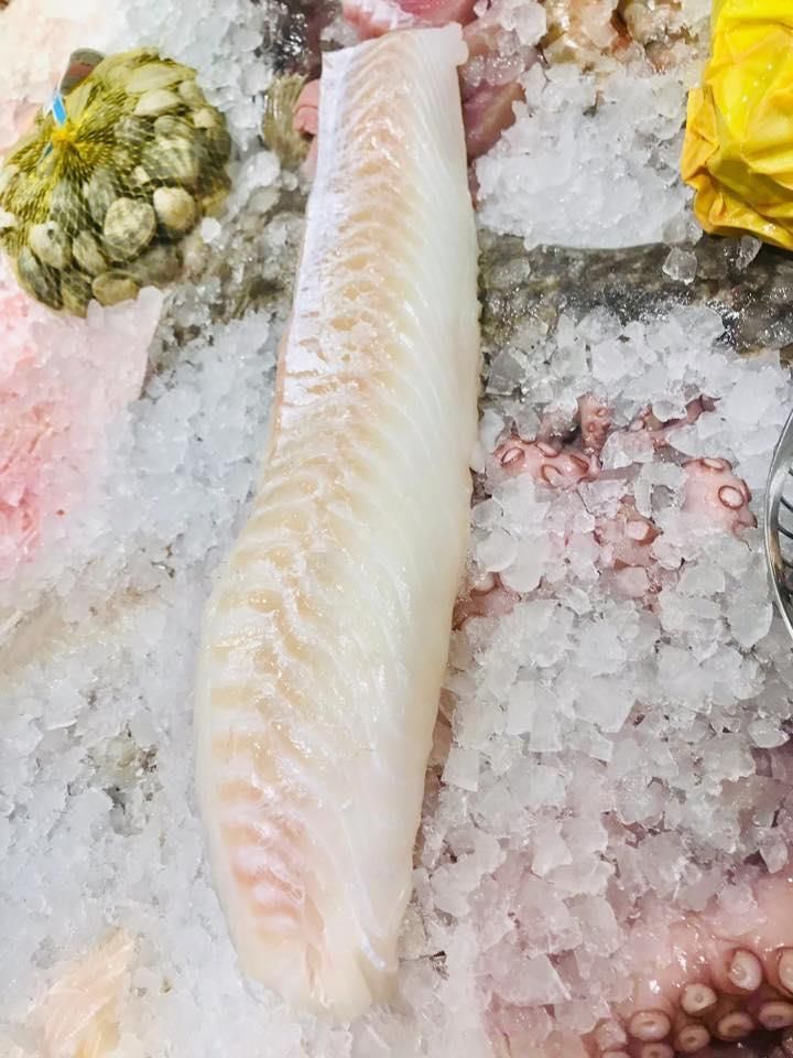 Ein Stück Fisch liegt auf einem Eishaufen.