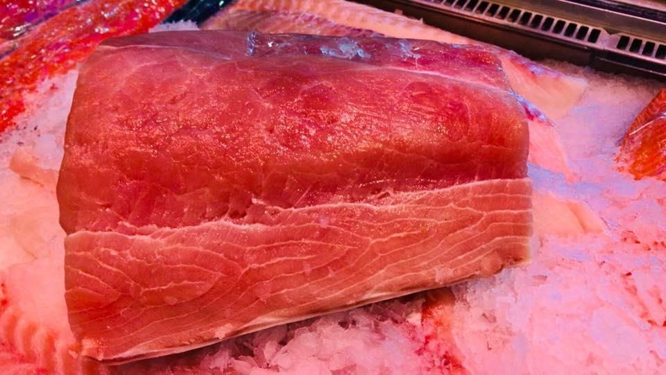 Ein Stück roher Thunfisch liegt auf Eis.